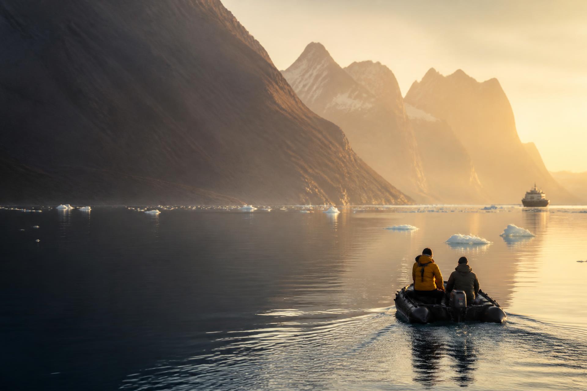 Two travelers in a small expedition boat crossing a golden fjord at sunrise, their ship far in the distance